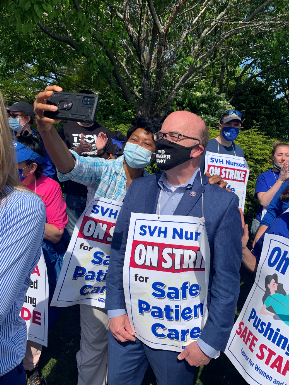 A striking nurse taking a selfie with Representative Jim McGovern